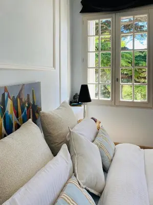 a living room with a couch with pillows and a window at Château Suite in Saint-Marcel