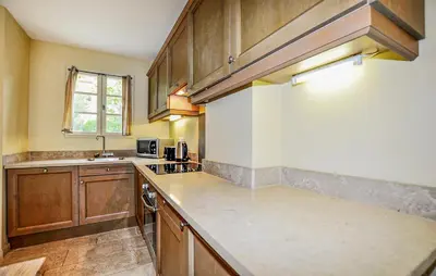 a large kitchen with wooden cabinets and a sink at 2 Bedroom Awesome Home In Saint-Laurent-De-La-Ca in Saint-Laurent-de-la-Cabrerisse