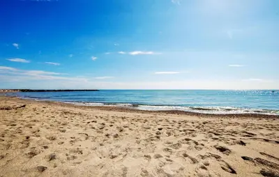 a beach with footprints in the sand and the ocean at 2 Bedroom Awesome Home In Saint-Laurent-De-La-Ca in Saint-Laurent-de-la-Cabrerisse