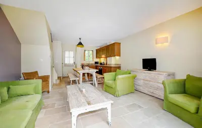 a living room with green chairs and a table at 2 Bedroom Awesome Home In Saint-Laurent-De-La-Ca in Saint-Laurent-de-la-Cabrerisse