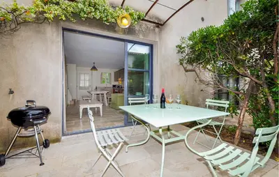 a table and chairs in a patio with a grill at 2 Bedroom Awesome Home In Saint-Laurent-De-La-Ca in Saint-Laurent-de-la-Cabrerisse