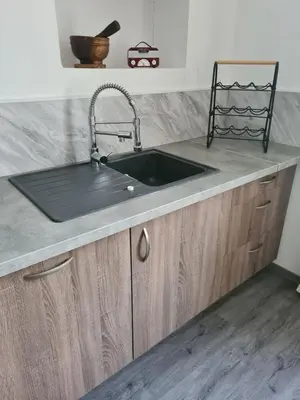 a kitchen with a sink and a counter at Appartement rénové avec jardin in Cuxac-dʼAude