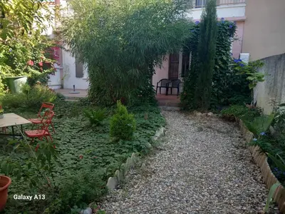 a garden with a tree and a table and chairs at Appartement rénové avec jardin in Cuxac-dʼAude