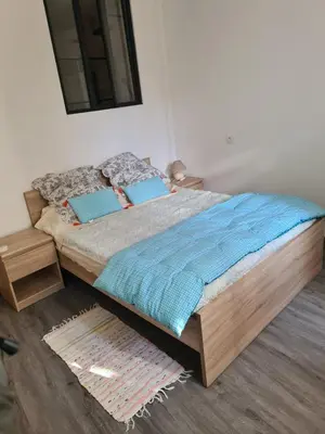a bedroom with a large bed with blue sheets at Appartement rénové avec jardin in Cuxac-dʼAude