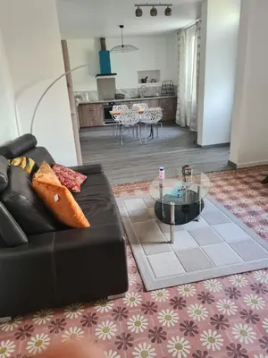 a living room with a couch and a table at Appartement rénové avec jardin in Cuxac-dʼAude
