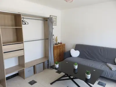 a living room with a couch and a table at Le Géranium in Port-la-Nouvelle
