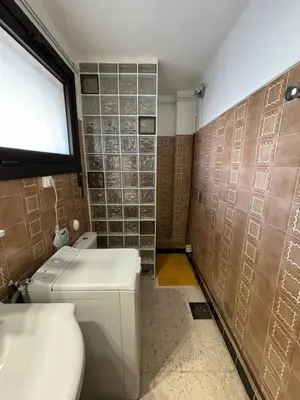a bathroom with a toilet and a sink and a window at Le Géranium in Port-la-Nouvelle