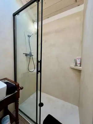 a shower with a glass door in a bathroom at Parenthèse en Forêt - Gîte Baliveau, Sidobre in Le Bez