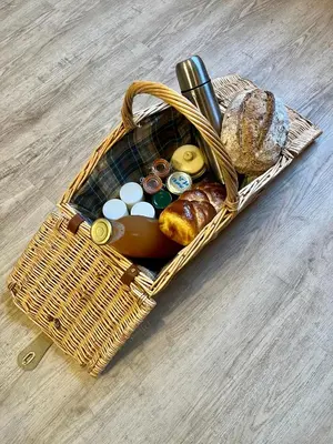 a picnic basket with bread and other items in it at Parenthèse en Forêt - Gîte Baliveau, Sidobre in Le Bez