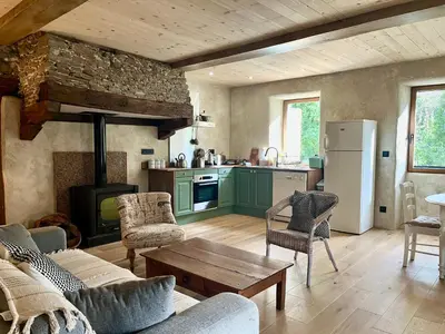 a living room with a couch and a table at Parenthèse en Forêt - Gîte Baliveau, Sidobre in Le Bez