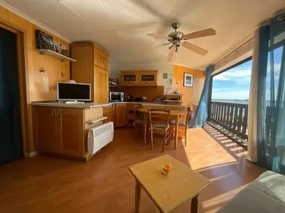 a living room with a kitchen and a balcony at Studio vue mer et plage in Gruissan
