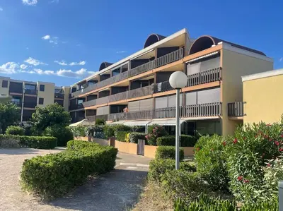 an apartment building with bushes in front of it at Studio vue mer et plage in Gruissan
