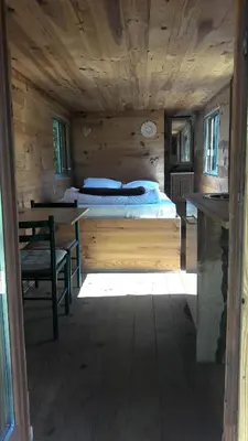 a bedroom with a bed and a desk in a cabin at Roulotte in Bugarach