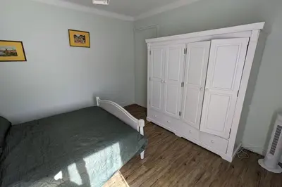 a bedroom with a bed and a large white cabinet at La Pinède in Espéraza