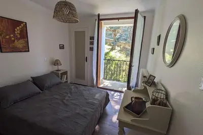 a bedroom with a bed and a large window at La Pinède in Espéraza
