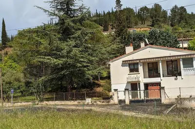 a white house with a fence in a field at La Pinède in Espéraza