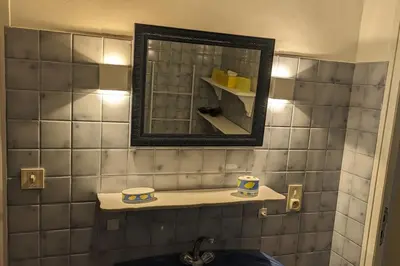 a bathroom with a mirror and a sink with two cups at La Pinède in Espéraza