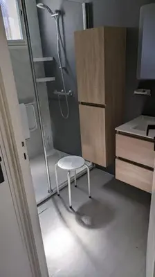 a bathroom with a shower and a chair in it at La Pinède in Espéraza