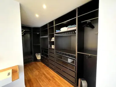 a black walk in closet with black cabinets and wood floors at Villa contemporaine avec piscine in Montredon