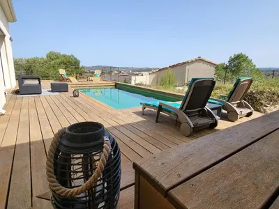 a deck with two chairs and a swimming pool at Villa contemporaine avec piscine in Montredon