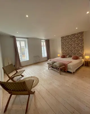 a large bedroom with a bed and a chair at Appartement standing proche plage in Fitou