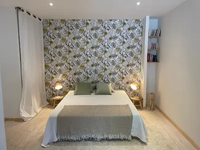a bedroom with a bed and a floral wall at Appartement standing proche plage in Fitou