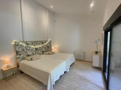 a bedroom with a bed with lights on it at Appartement standing proche plage in Fitou