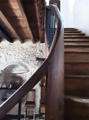 a staircase with a wooden railing in a building at Gîte Dűrer in Fanjeaux