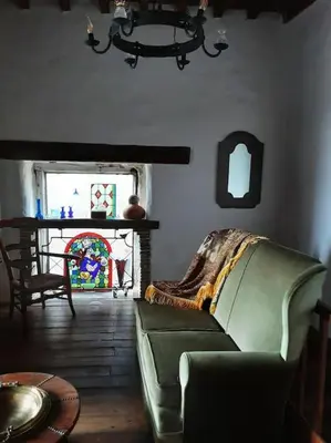 a living room with a green couch and a table at Gîte Dűrer in Fanjeaux