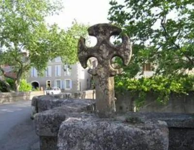 a stone cross on the side of a street at Gîte Dűrer in Fanjeaux