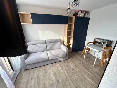 a living room with a couch and a table at Superbe Studio avec vue sur le port de Gruissan, piscine, parking in Gruissan