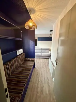 a room with a hallway with a couch and a light at Superbe Studio avec vue sur le port de Gruissan, piscine, parking in Gruissan