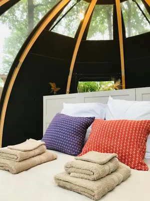 a bed with three pillows and towels on it at Ô cocon del Lauragués in Ricaud