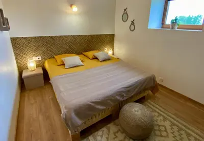 a bedroom with a bed with two pillows and a window at Séjour confort et nature in Saint-Amans-Valtoret