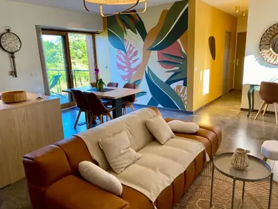 a living room with a couch and a table at Séjour confort et nature in Saint-Amans-Valtoret
