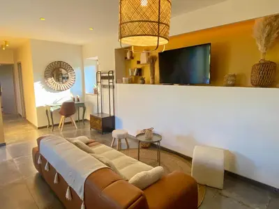 a living room with a couch and a flat screen tv at Séjour confort et nature in Saint-Amans-Valtoret