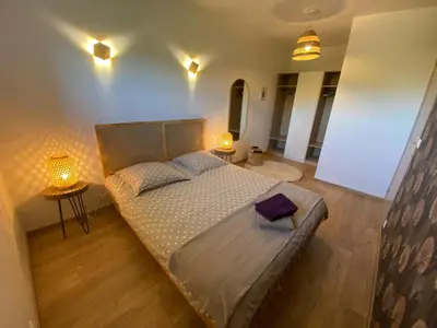 a bedroom with a large bed and two lamps at Séjour confort et nature in Saint-Amans-Valtoret