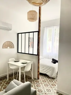 a living room with a table and a bed at Le Briguiboul l Rez-de-chaussée l Stationnement gratuit in Castres