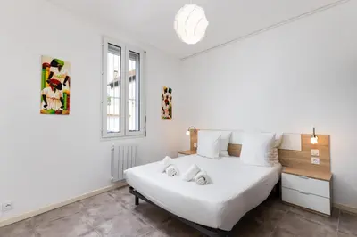 a bedroom with a white bed with two stuffed animals on it at L'atelier De La Cite - Parking Gratuit Sécurisé in Carcassonne