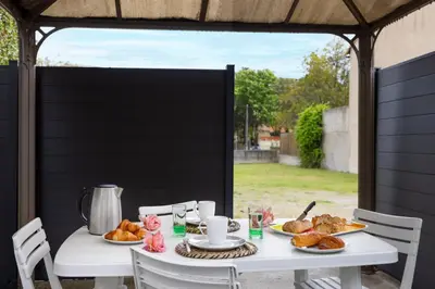 a white table with bread and croissants on it at L'atelier De La Cite - Parking Gratuit Sécurisé in Carcassonne