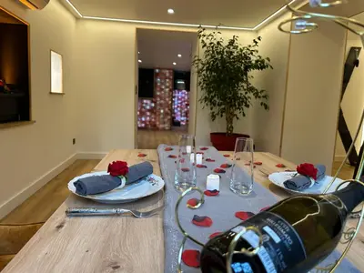 a wooden table with a bottle of wine on it at Eden de Roques in Castres