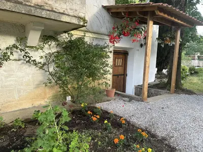 a house with a wooden door and a flower garden at Eden de Roques in Castres