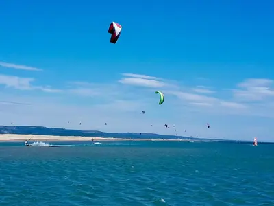 a group of kites flying in the sky over the ocean at - L'Horizon Bleu - Cocon romantique avec vue mer panoramique in Gruissan
