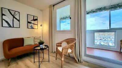 a living room with a couch and a window at - L'Horizon Bleu - Cocon romantique avec vue mer panoramique in Gruissan