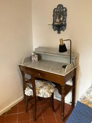 a desk with a lamp on top of it in a room at ChezMathilde à LIMOUX in Limoux
