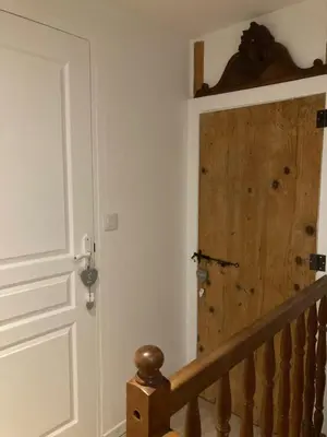 a wooden door in a room with a staircase at ChezMathilde à LIMOUX in Limoux
