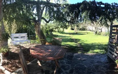 a wooden table and chairs under a tree at ChezMathilde à LIMOUX in Limoux