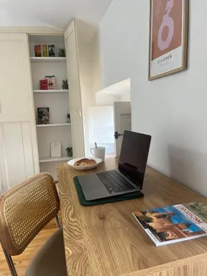 a laptop computer sitting on top of a wooden table at Le Charmant Boisé - T2 Centre Ville 7 min Cité Médiévale in Carcassonne