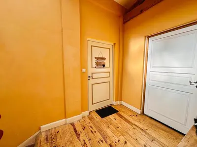 an orange room with a white door and a wooden floor at Le Charmant Boisé - T2 Centre Ville 7 min Cité Médiévale in Carcassonne