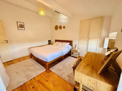 a small bedroom with a bed and a table at Le Charmant Boisé - T2 Centre Ville 7 min Cité Médiévale in Carcassonne
